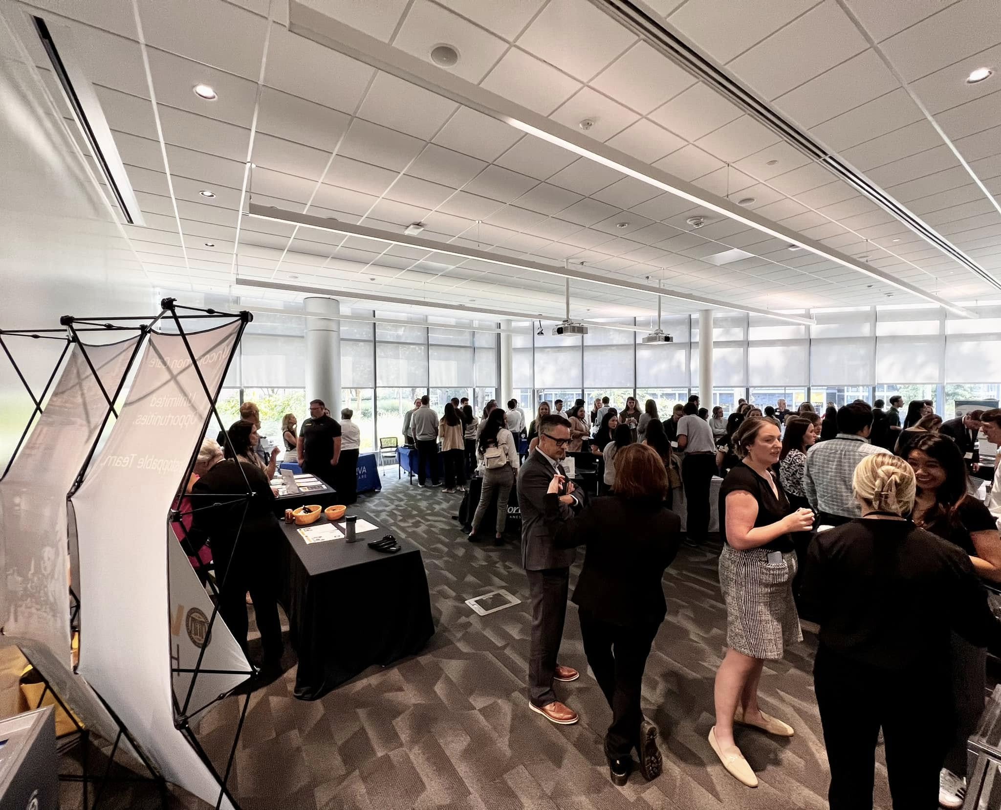 Large group of students and faculty networking in CHP classroom.